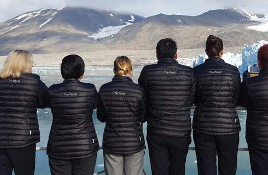 group of people looking at mountains on deck of ship