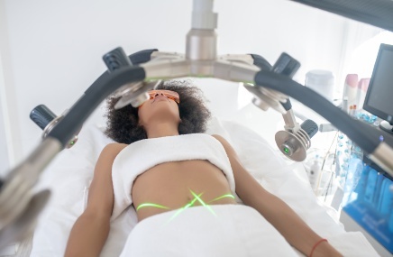 woman laying on bed getting body sculpting