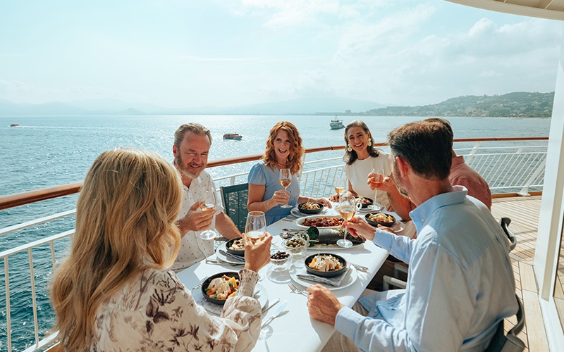 group of people eating dinner on ship deck